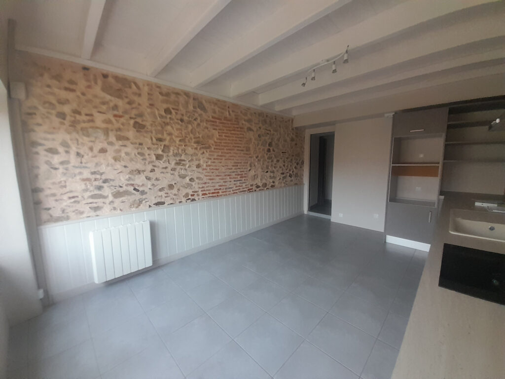 maison à vendre Les Herbiers pièce de vie avec mur en pierre apparente et cuisine ouverte